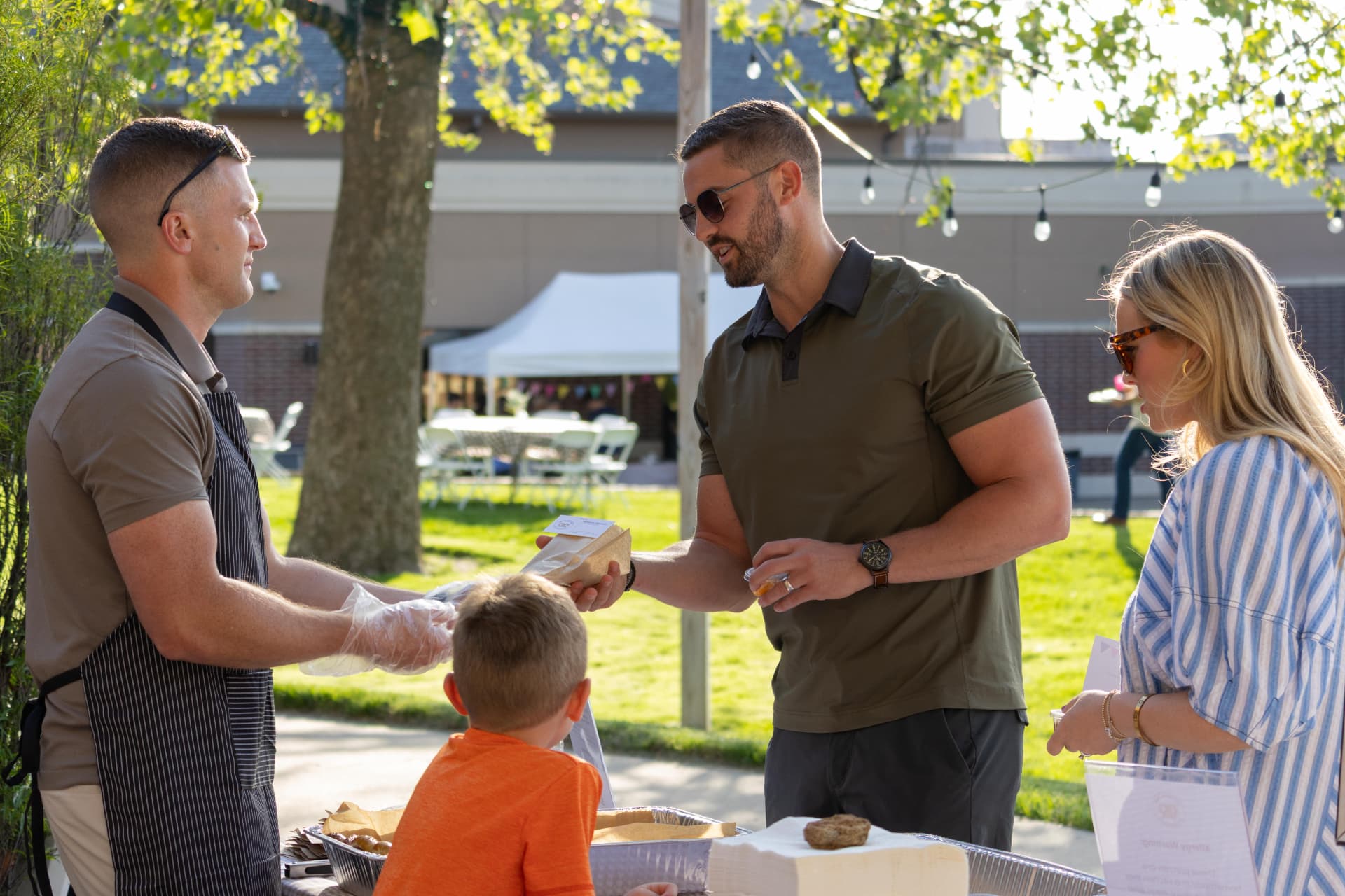 Nathan handing a fresh pretzel to a guest at an outdoor event