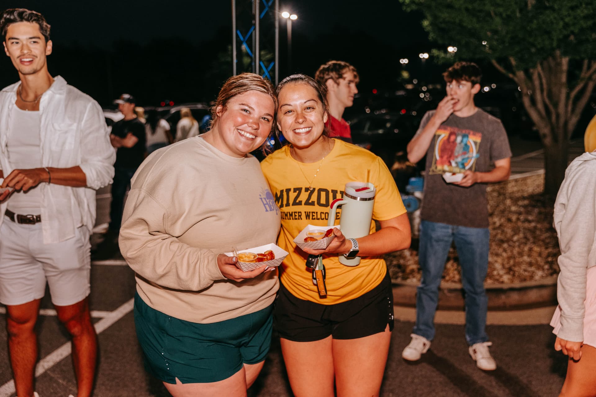 Two friends holding trays of pretzel bites